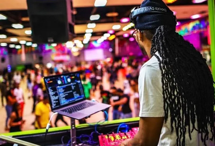 dj looking out over crowd playing music off his computer