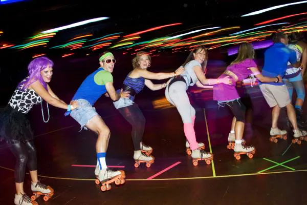 group of six adults skating and forming a congo line